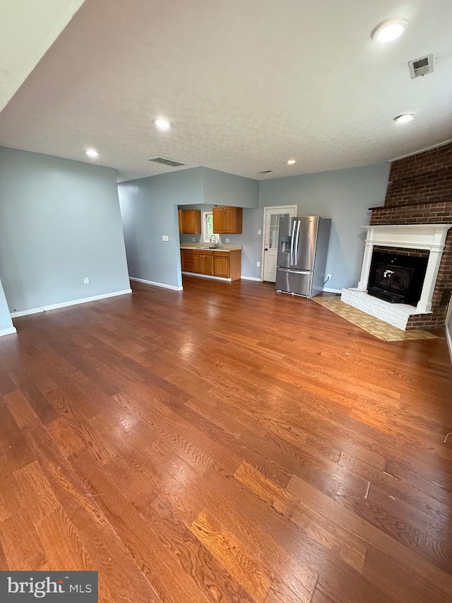 7421 Lake Dr, Manassas, VA 20111 - unfurnished living room featuring dark wood-style flooring, a sink, a fireplace, baseboards, and recessed lighting