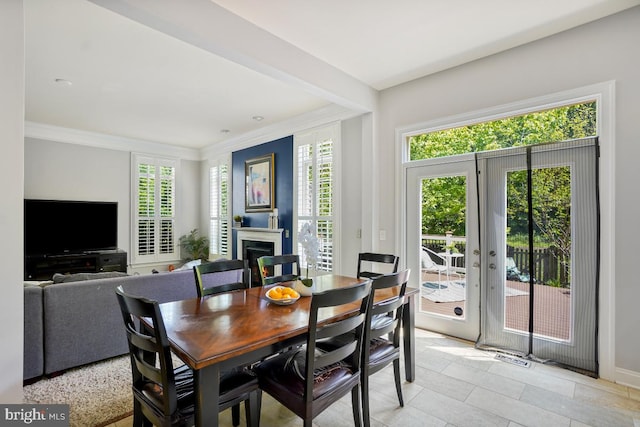 42743 Macauley Pl, Ashburn, VA 20148 - dining room with crown molding, a warm lit fireplace, baseboards, and light tile patterned floors