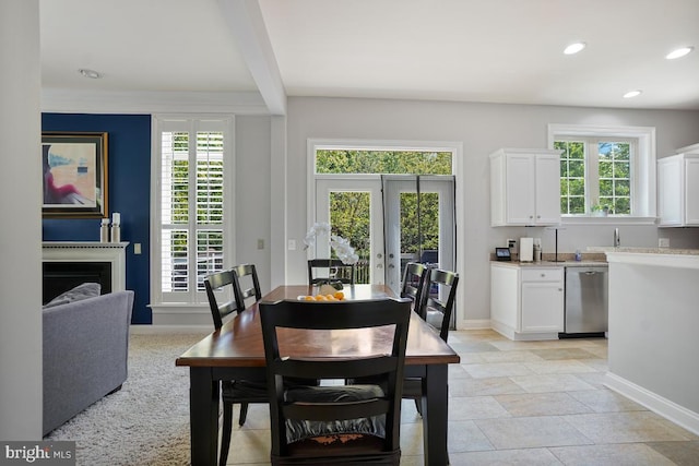 42743 Macauley Pl, Ashburn, VA 20148 - dining area featuring french doors, baseboards, a fireplace, recessed lighting, and light stone finish flooring