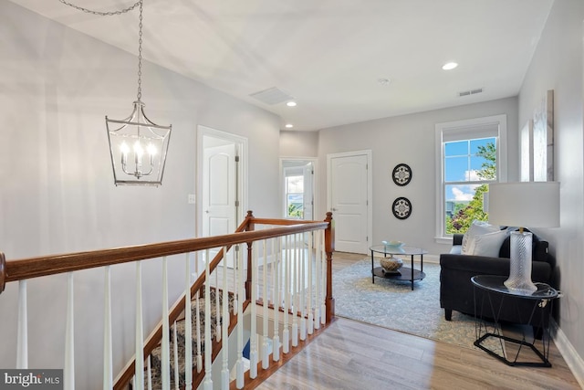42743 Macauley Pl, Ashburn, VA 20148 - hall featuring light wood-style flooring, healthy amount of natural light, a chandelier, recessed lighting, and an upstairs landing