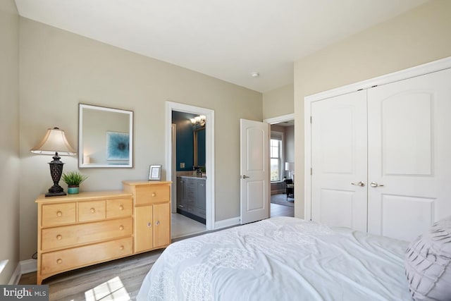 42743 Macauley Pl, Ashburn, VA 20148 - bedroom with wood finished floors, a closet, baseboards, and connected bathroom