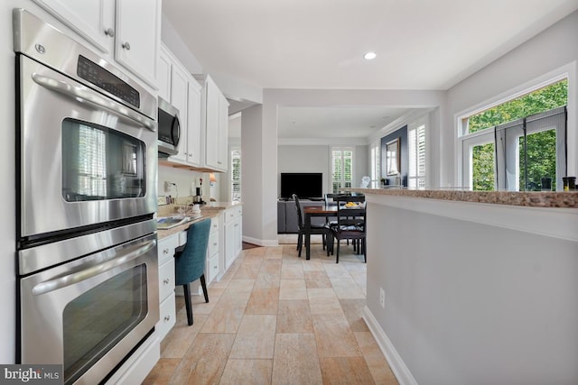 42743 Macauley Pl, Ashburn, VA 20148 - kitchen featuring appliances with stainless steel finishes, white cabinets, recessed lighting, baseboards, and open floor plan