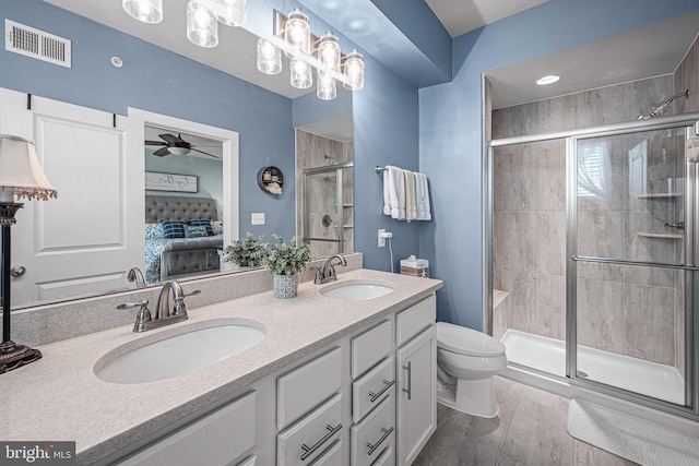 3451 Flatwoods Dr, Frederick, MD 21704 - ensuite bathroom with ceiling fan, a shower stall, toilet, double vanity, and wood finished floors