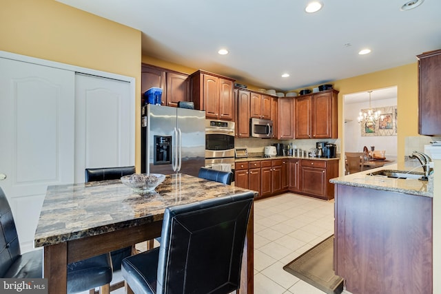 15603 Chadsey Ln, Brandywine, MD 20613 - kitchen featuring stainless steel appliances, a sink, a chandelier, light stone countertops, and light tile patterned floors