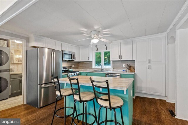272 Main St, Hamilton, NJ 08620 - kitchen with stainless steel appliances, dark wood-style flooring, a sink, stacked washer and clothes dryer, and white cabinetry