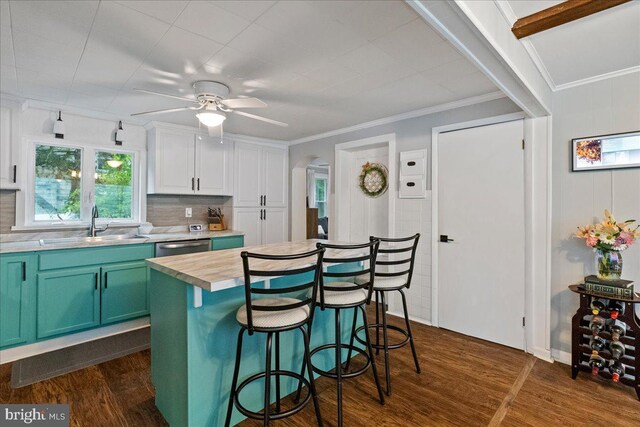 272 Main St, Hamilton, NJ 08620 - kitchen featuring a sink, dark wood-type flooring, a kitchen bar, a ceiling fan, and crown molding