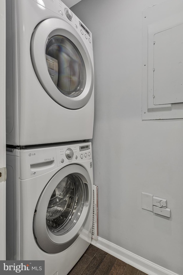 402 Bay View Dr, Edgewater, MD 21037 - laundry room featuring stacked washer / drying machine, electric panel, dark wood-type flooring, and baseboards