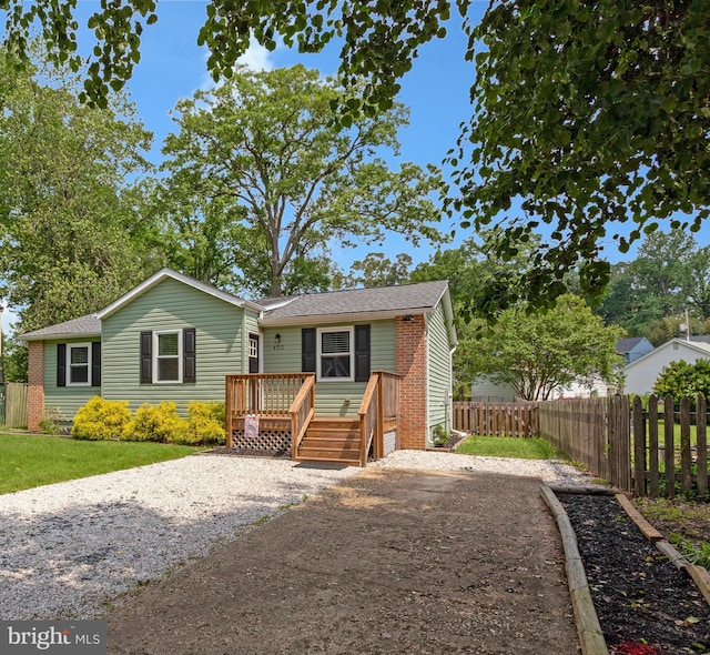 402 Bay View Dr, Edgewater, MD 21037 - view of front of home featuring a wooden deck, fence, a shingled roof, and brick siding