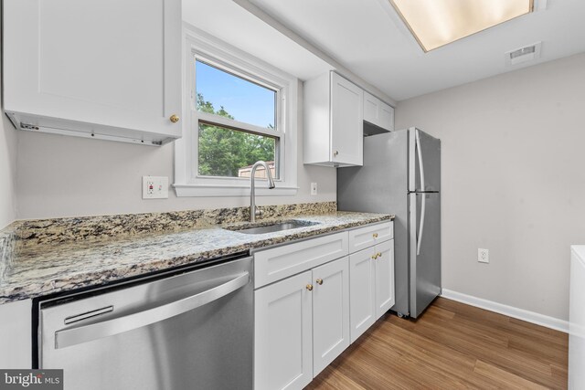 9048 Bonham Cir, Manassas, VA 20110 - kitchen with stainless steel appliances, a sink, white cabinetry, and wood finished floors