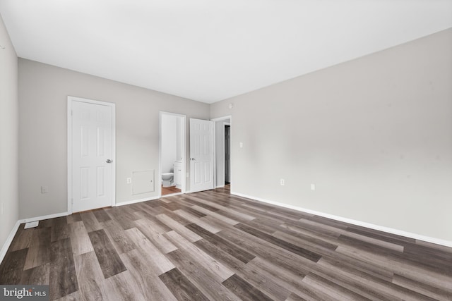 9048 Bonham Cir, Manassas, VA 20110 - unfurnished bedroom with wood finished floors, baseboards, and connected bathroom