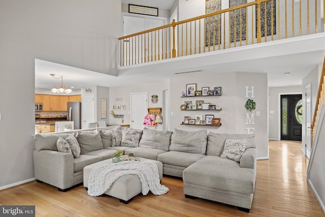 106 Hedgerow Ct, Deptford, NJ 08096 - living room featuring a high ceiling, a chandelier, light wood-style floors, and baseboards