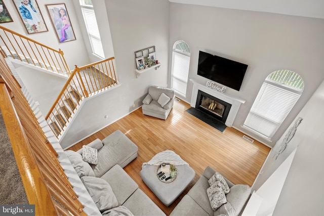 106 Hedgerow Ct, Deptford, NJ 08096 - living area with plenty of natural light, wood finished floors, a glass covered fireplace, a high ceiling, and stairs