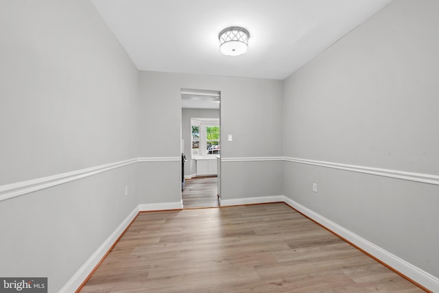 unfurnished room with light wood-style flooring and baseboards