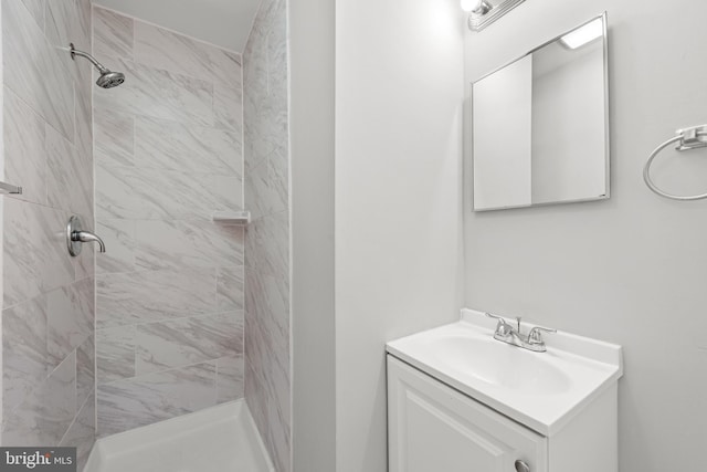 bathroom featuring a tile shower and vanity