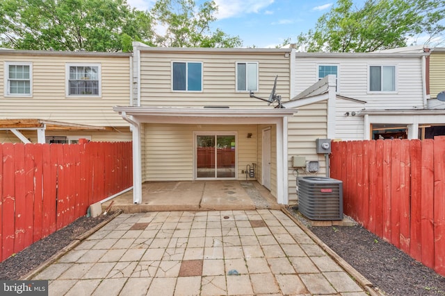 rear view of house featuring central AC unit, a patio, and fence