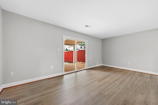 spare room with wood finished floors and baseboards