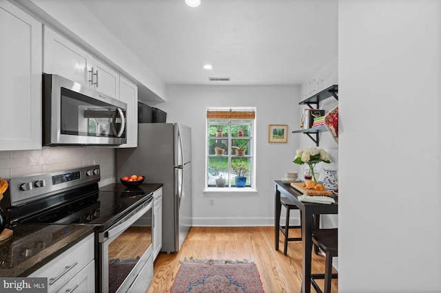 922 Montgomery Ave Unit E2, Bryn Mawr, PA 19010 - kitchen featuring appliances with stainless steel finishes, tasteful backsplash, light wood-style flooring, white cabinetry, and baseboards