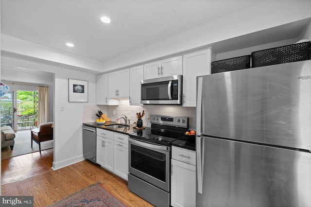 922 Montgomery Ave Unit E2, Bryn Mawr, PA 19010 - kitchen with stainless steel appliances, a sink, dark countertops, white cabinets, and recessed lighting
