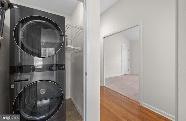 36518 Harmon Bay Blvd Unit 27, Rehoboth Beach, DE 19971 - washroom featuring stacked washing machine and dryer, baseboards, and wood finished floors