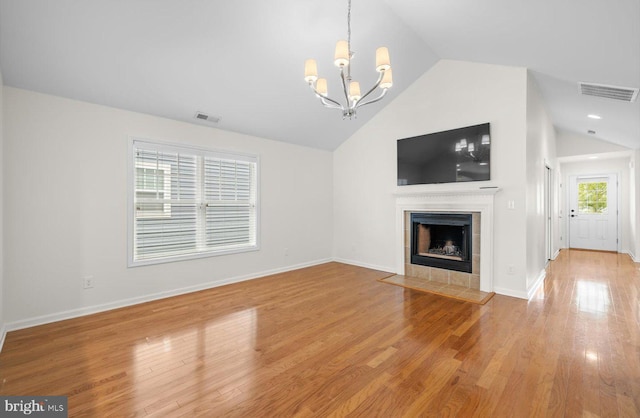 36518 Harmon Bay Blvd Unit 27, Rehoboth Beach, DE 19971 - unfurnished living room featuring lofted ceiling, a chandelier, a fireplace, wood finished floors, and baseboards