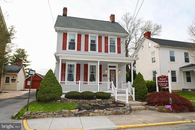 view of front of home featuring covered porch and a chimney