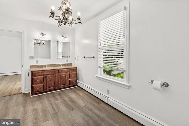 201 E Main St, Fairfield, PA 17320 - full bath with a chandelier, a baseboard heating unit, double vanity, wood finished floors, and baseboard heating