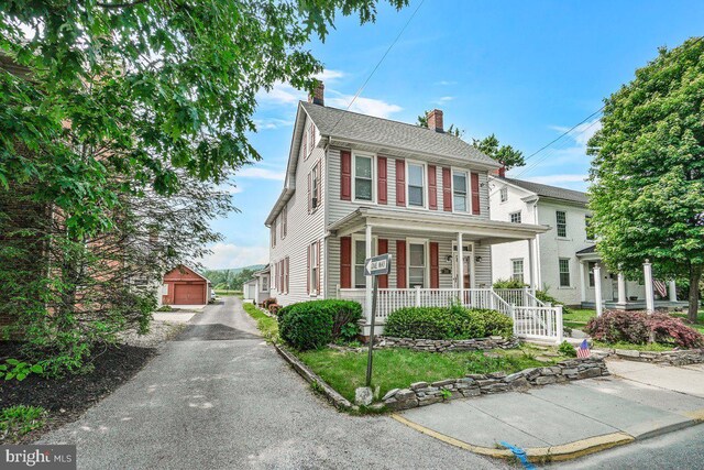 201 E Main St, Fairfield, PA 17320 - view of front of home featuring covered porch, a chimney, a detached garage, and an outbuilding