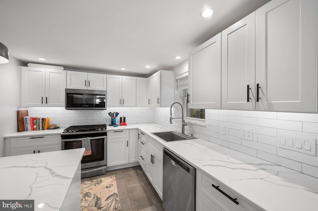 1505 Wynnewood Rd, Ardmore, PA 19003 - kitchen featuring stainless steel appliances, white cabinets, backsplash, light stone countertops, and recessed lighting