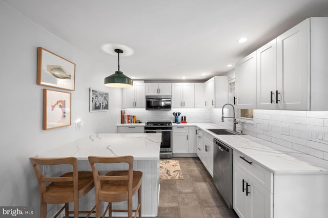 1505 Wynnewood Rd, Ardmore, PA 19003 - kitchen featuring stainless steel appliances, light stone countertops, a kitchen bar, tasteful backsplash, and recessed lighting