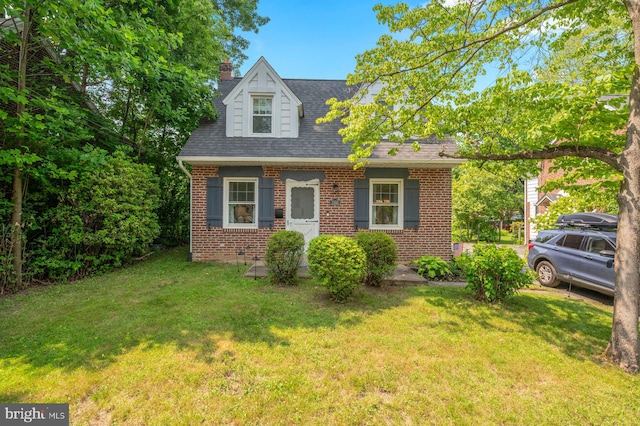 1505 Wynnewood Rd, Ardmore, PA 19003 - cape cod home with brick siding, a front yard, a chimney, and roof with shingles