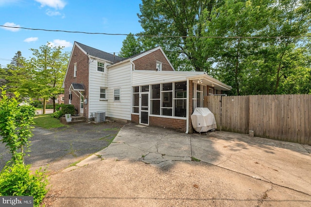 1505 Wynnewood Rd, Ardmore, PA 19003 - rear view of house featuring a sunroom, brick siding, and a patio