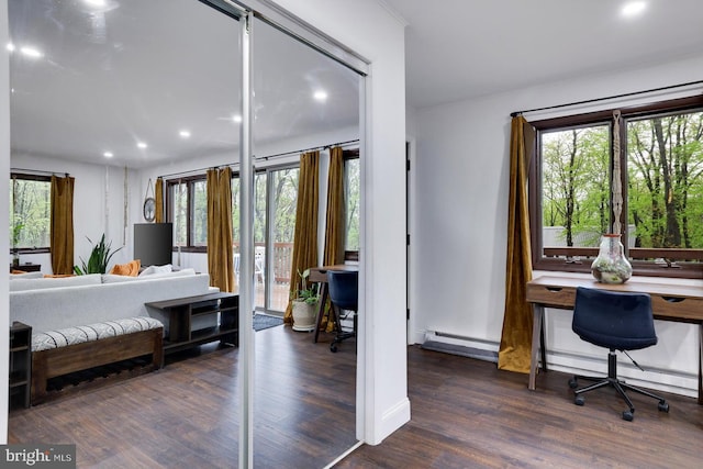 bedroom featuring baseboard heating, wood finished floors, a baseboard heating unit, recessed lighting, and access to outside