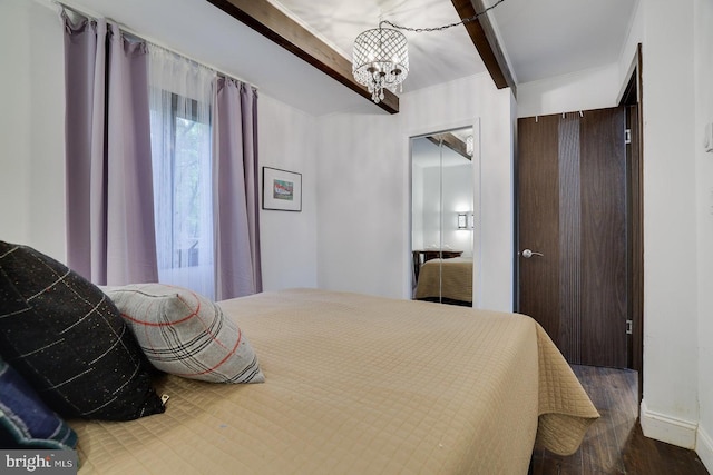 bedroom featuring a chandelier, wood finished floors, and beam ceiling