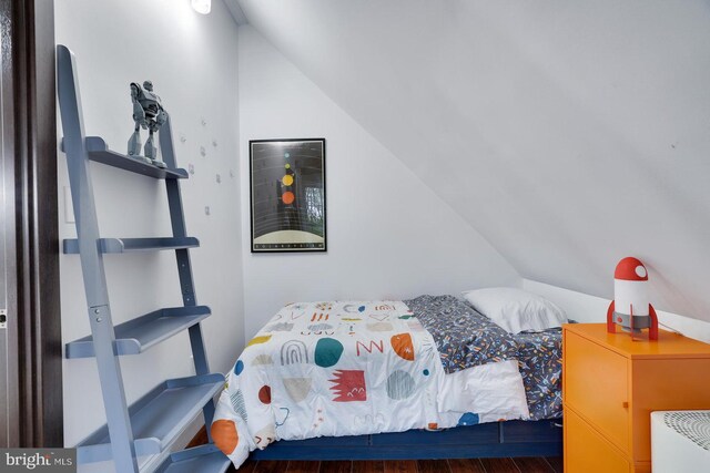 bedroom featuring lofted ceiling and wood finished floors