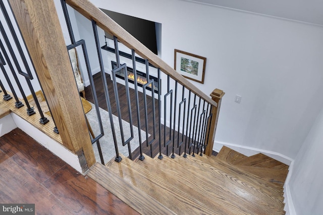stairway featuring wood finished floors and baseboards