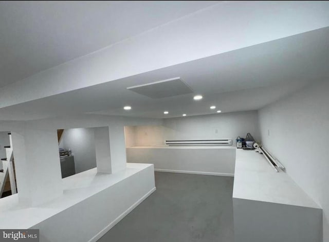 hallway with recessed lighting, concrete flooring, and baseboards