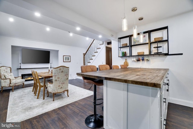 dining room with stairs, dark wood-style floors, baseboards, recessed lighting, and bar area