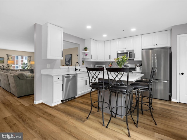 1413 Peregrine Path, Arnold, MD 21012 - kitchen featuring appliances with stainless steel finishes, wood finished floors, a kitchen bar, light countertops, and recessed lighting