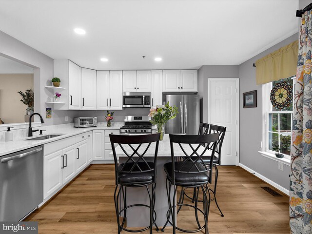 1413 Peregrine Path, Arnold, MD 21012 - kitchen with appliances with stainless steel finishes, a sink, light countertops, a kitchen breakfast bar, and white cabinetry