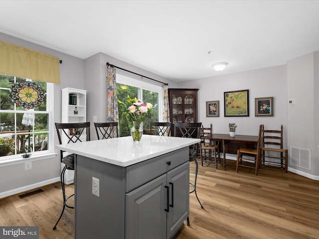 1413 Peregrine Path, Arnold, MD 21012 - kitchen with gray cabinetry, a kitchen breakfast bar, light wood-type flooring, and baseboards