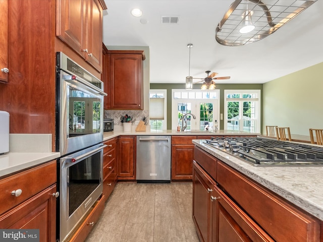 106 Bedrock Dr, Walkersville, MD 21793 - kitchen featuring stainless steel appliances, a sink, ceiling fan, light countertops, and backsplash