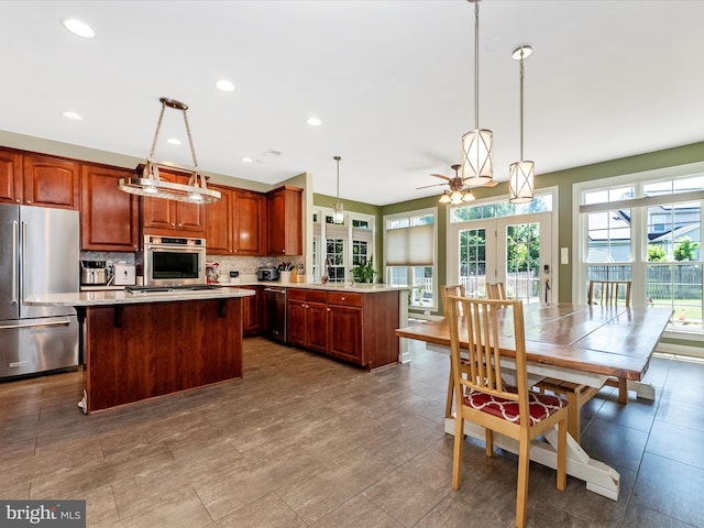 106 Bedrock Dr, Walkersville, MD 21793 - kitchen with appliances with stainless steel finishes, decorative backsplash, hanging light fixtures, a center island, and recessed lighting