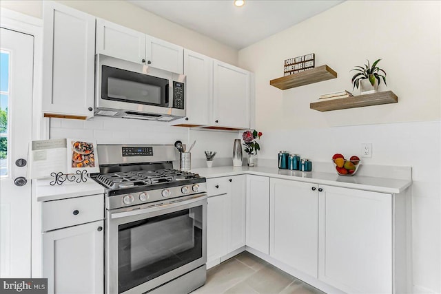 564 9th Ave, Prospect Park, PA 19076 - kitchen featuring appliances with stainless steel finishes, open shelves, light countertops, white cabinets, and decorative backsplash