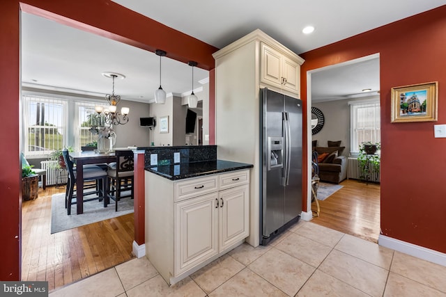 806 S Beechfield Ave, Baltimore, MD 21229 - kitchen with stainless steel fridge with ice dispenser, a chandelier, light tile patterned floors, radiator heating unit, and ornamental molding
