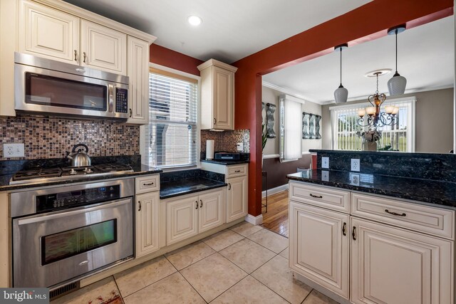 806 S Beechfield Ave, Baltimore, MD 21229 - kitchen with appliances with stainless steel finishes, cream cabinets, crown molding, tasteful backsplash, and light tile patterned floors
