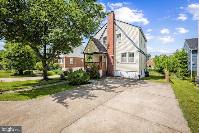 806 S Beechfield Ave, Baltimore, MD 21229 - view of front of home with a chimney, concrete driveway, a front lawn, and central air condition unit