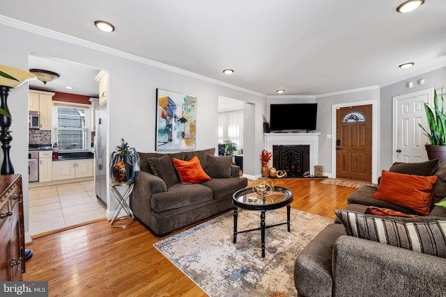 806 S Beechfield Ave, Baltimore, MD 21229 - living area featuring healthy amount of natural light, light wood-style floors, crown molding, a fireplace, and recessed lighting