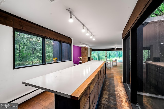 kitchen with baseboard heating, light countertops, a center island, and track lighting