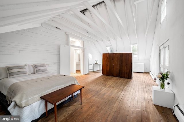 bedroom featuring a baseboard heating unit, hardwood / wood-style floors, and wood walls