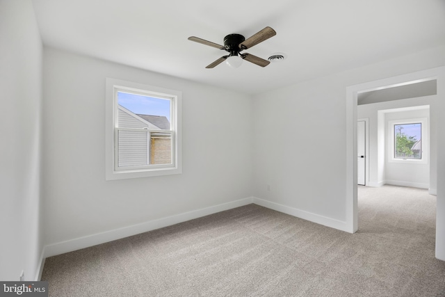 spare room featuring carpet flooring, baseboards, and ceiling fan